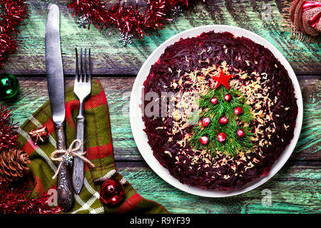 Vegetable salad from beetroot with Christmas tree decoration on the green table at New Year time Stock Photo