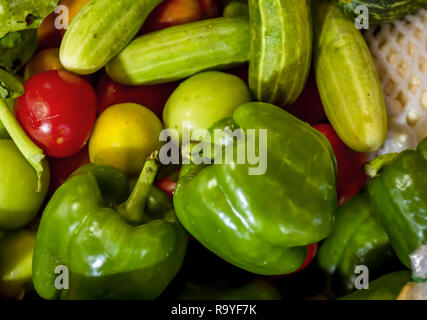 Assorted vegetables at Asian Market in Siem Reap. Cucumbers, green bell pepper, tomatoes, apples. Stock Photo