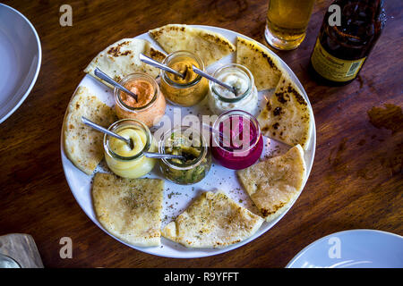 plate of flat bread and assorted humus in jars. Stock Photo