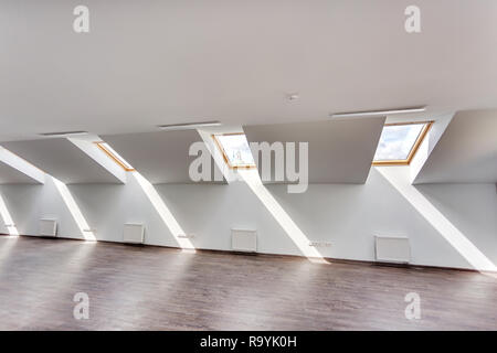 Side view of unfurnished room interior with wooden floor on roof floor, white walls   with bright dayligh Stock Photo