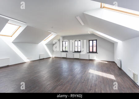 Side view of unfurnished room interior with wooden floor on roof floor, white walls   with bright dayligh Stock Photo