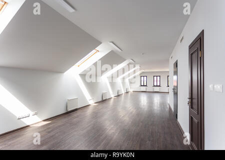Side view of unfurnished room interior with wooden floor on roof floor, white walls   with bright dayligh Stock Photo