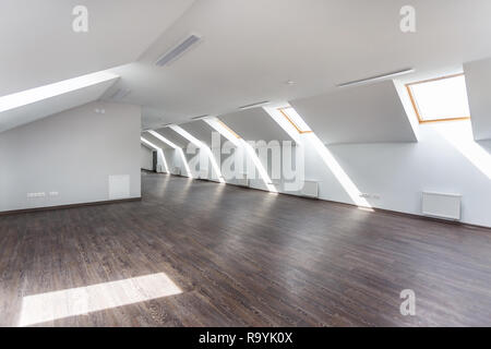 Side view of unfurnished room interior with wooden floor on roof floor, white walls   with bright dayligh Stock Photo
