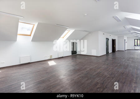 Side view of unfurnished room interior with wooden floor on roof floor, white walls   with bright dayligh Stock Photo