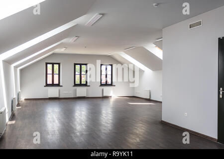 Side view of unfurnished room interior with wooden floor on roof floor, white walls   with bright dayligh Stock Photo