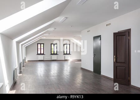 Side view of unfurnished room interior with wooden floor on roof floor, white walls   with bright dayligh Stock Photo