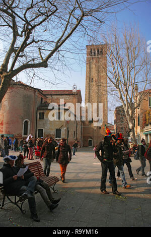 Campo San Giacomo dell' Orio, Santa Croce, Venice, Italy: belltower and crowds enjoying the sun Stock Photo