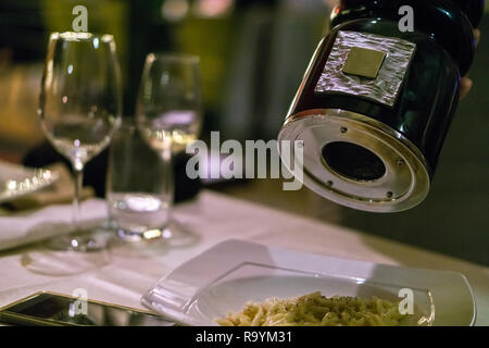 Male chef spicing pasta with pepper in a restaurant Stock Photo