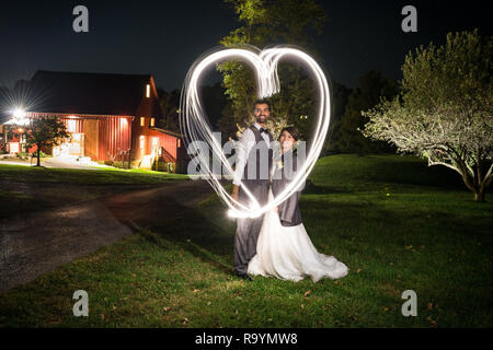 Creative long exposure light painting with bride and groom portraits after a wedding reception. Stock Photo