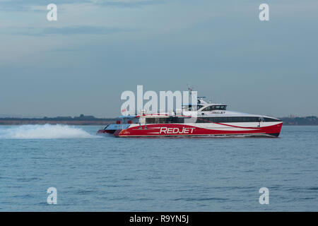 Red jet hi-speed catamaran ferry crossing the Solent between Southampton and West Cowes on the Isle of Wight Stock Photo