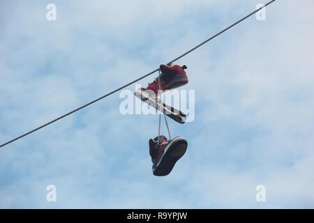 Pair Of Shoes Hanging Over Power Line Stock Photo