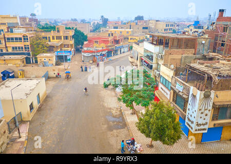 GIZA, EGYPT - DECEMBER 20, 2017: The urban scene of Giza town with old residential houses, numerous tourist cafes and street food vendor, selling food Stock Photo