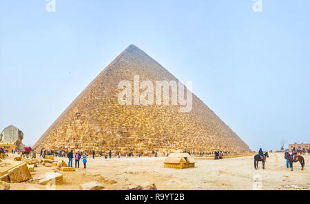 GIZA, EGYPT - DECEMBER 20, 2017: The crowds of tourists  at the foot of the Pyramid of Khufu, the biggest Pyramid in complex, on December 20 in Giza Stock Photo