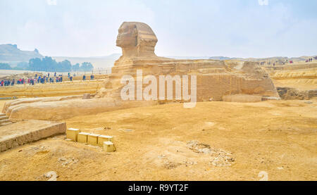 GIZA, EGYPT - DECEMBER 20, 2017: The tourist groups on the Sphinx viewing area exploring remains of ancient Egyptian architecture, on December 20 in G Stock Photo