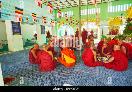 SAGAING, MYANMAR - FEBRUARY 21, 2018: The bhikkhu monks on lunch in hall of Yaza Mani Sula Kaunghmudaw Pagoda, on February 21 in Sagaing. Stock Photo