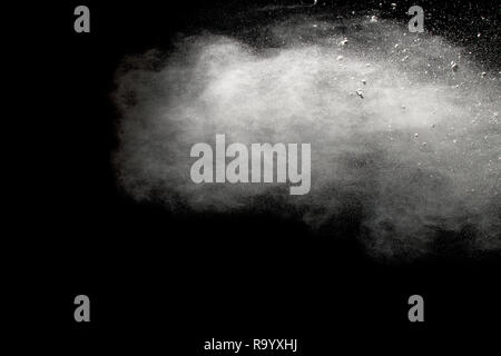 Bizarre forms of  white powder explosion on white background.Launched white dust particles splash on dark background. Stock Photo