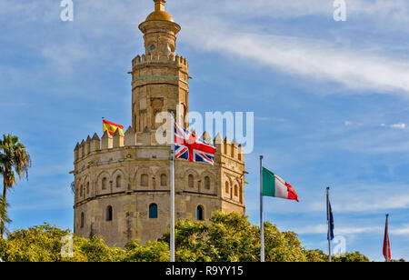 SEVILLE SPAIN THE TOWER OF GOLD OR TORRE DEL ORO AND FLAGS ON THE BANKS OF THE GUADALQUIVIR RIVER Stock Photo