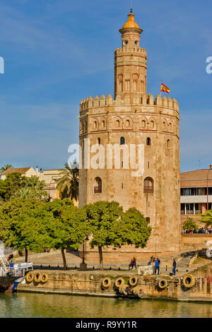 SEVILLE SPAIN THE TOWER OF GOLD OR TORRE DEL ORO ON THE BANKS OF THE GUADALQUIVIR RIVER WITH PEOPLE Stock Photo