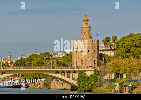 SEVILLE SPAIN THE TOWER OF GOLD OR TORRE DEL ORO ON THE BANKS OF THE GUADALQUIVIR RIVER WITH THE TELMO BRIDGE Stock Photo