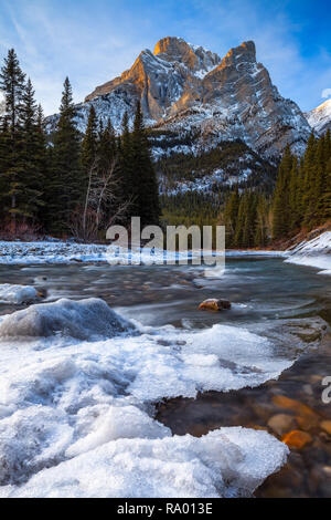 Mount Kidd, a mountain in Kananaskis in the Canadian Rocky Mountains, Alberta, Canada and the Kananaskis River in winter Stock Photo