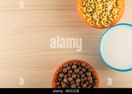 Chocolate and honey cornflakes with milk in colorful bowls Stock Photo