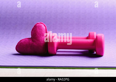 Shaping and fitness equipment. Dumbbells made of pink plastic near