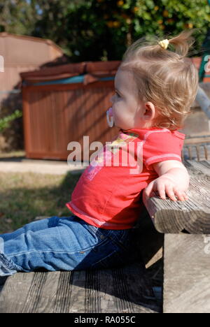 cute little girl sitting outside Stock Photo
