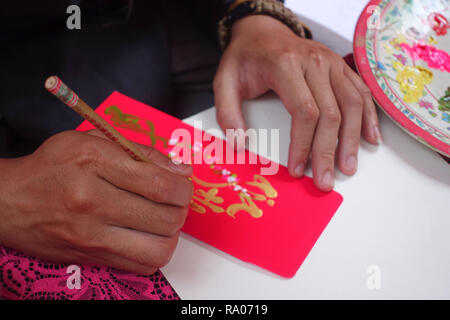 Scholar writes calligraphy characters in new year. The calligrapher draw handwriting in penmanship at fair in springtime. Culture of Vietnamese Stock Photo