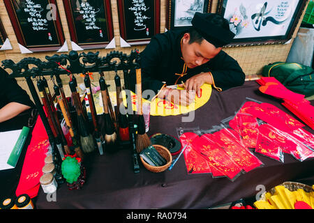 Vietnamese scholar writes calligraphy at lunar new year. Calligraphy festival is a popular tradition during Tet holiday. Culture of Vietnamese Tet Stock Photo