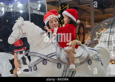 Bangkok, , Thailand - December 16, 2018: Mom and daughter enjoying the holidays in Christmas outfits in Bangkok. Stock Photo