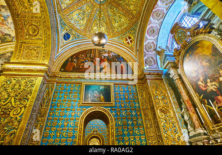 VALLETTA, MALTA - JUNE 18, 2018: The ornate interior of chapel of the Langue of Italy in St John's Co-Cathedral with carved gilt patterns on walls and Stock Photo