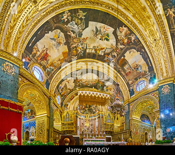 VALLETTA, MALTA - JUNE 18, 2018: Panorama of stunning High Altar of St John's Co-Cathedral with ornate decorations in Baroque style, on June 18 in Val Stock Photo