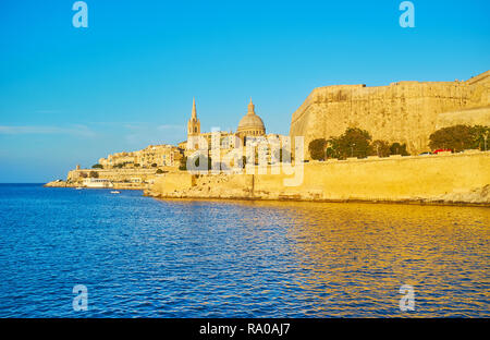 Enjoy the city of Valletta from the Northern Harbour, St Paul's Pro-Cathedral and Carmelite Church are seen amid the medieval walls, lighted with sun  Stock Photo