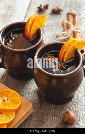 Hot mulled wine with orange, cinnamon, honey and anise on wooden background. Stock Photo
