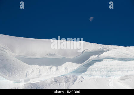 Antarctica, Antarctic peninsula, Gerlach Straight, Wilhelmina Bay in the Enterprise Island area. Moon over snowy mountain edge. Stock Photo