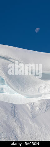 Antarctica, Antarctic peninsula, Gerlach Straight, Wilhelmina Bay in the Enterprise Island area. Moon over snowy mountain edge. Stock Photo