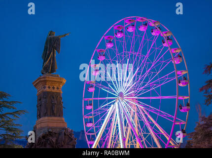 The big panoramic wheel in Dante Alighieri square in Trento city at night during the Christmas festivity. Christmas market in Trento, Trentino Alto Ad Stock Photo