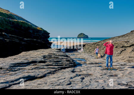 Trebarwith, Cornwall, UK - October 10, 2018: People at Trebarwith Strand beach with view to the Gull Rock in North Cornwall, England. Stock Photo