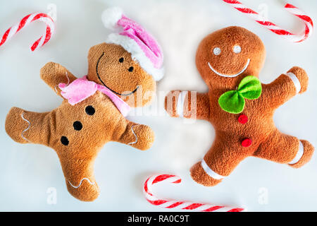 Flat lay of a gingerbread men and lady surrounded by candy canes. Stock Photo