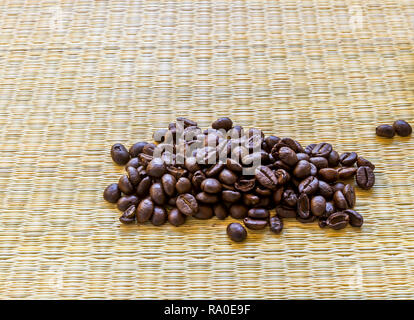 Loose coffee beans on a weaved type matt in Asia. Stock Photo