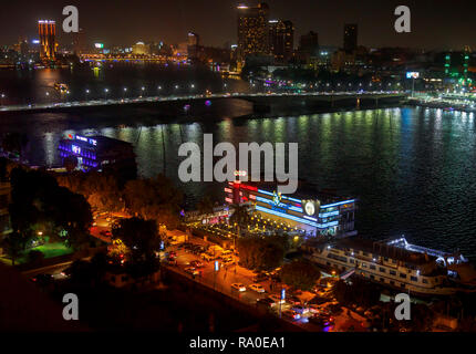 Floating restaurants, TGI Fridays, Grand CafŽ, Fish Market, on boats moored on the River Nile, Giza, Cairo, Egypt at night by Cairo University Bridge Stock Photo