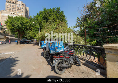 Fish Market restaurant food delivery motorbikes parked by the roadside on a sunny day in Giza, Cairo, Egypt Stock Photo