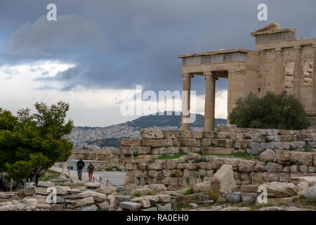 Awesome view of Parthenon taken against the background of the clouded sky over the silhouette of the city of Athens seen from above. Stock Photo