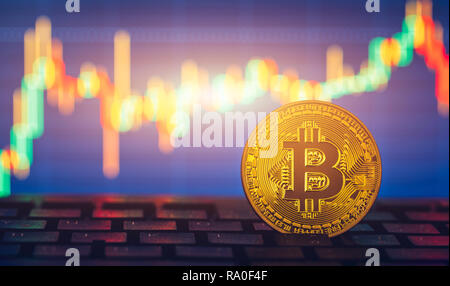 Bitcoin gold coin and defocused chart background. Virtual cryptocurrency concept. Bitcoins on ladder chart cryptocurrency concept. Bitcoin currency wi Stock Photo