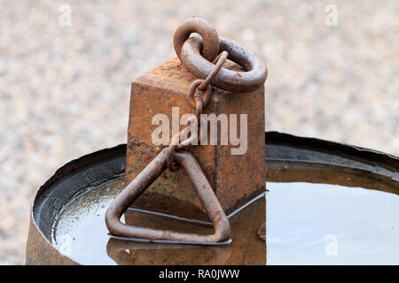 Old Cast Iron Weight on wooden  barrel Stock Photo