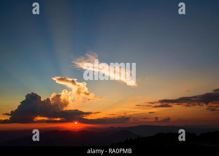 Sunset orange sun and clouds from the top of mountains Stock Photo
