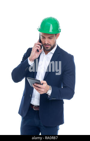 Construction manager calling and using tablet isolated on white background Stock Photo
