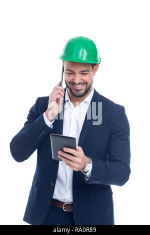 Happy young construction manager calling and using tablet isolated on white background Stock Photo