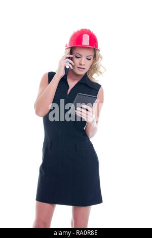 Young busy construction manager woman calling and using tablet isolated on white background Stock Photo