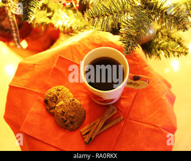 hot coffee and biscuits in front of the Christmas tree - cozy Christmas home scene Stock Photo